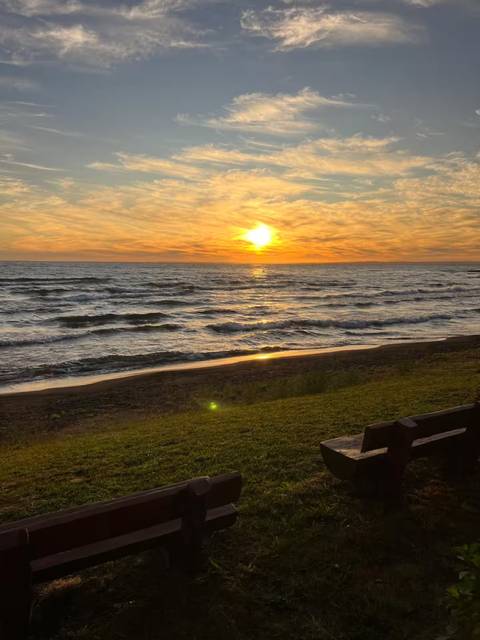 Atardecer en la orilla del lago Llanquihue, con bancas frente al agua